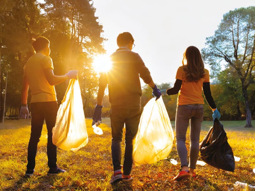 Tre volontari che ripuliscono un parco
